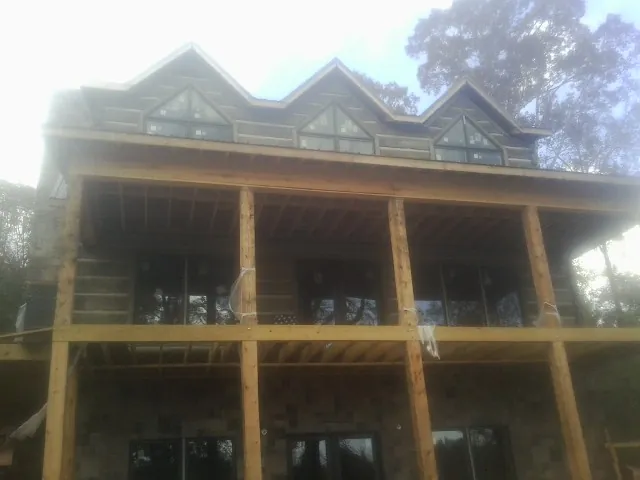 Dormers and porch framing on a large log home under construction — Roof Coating work by our crew in Cedarburg