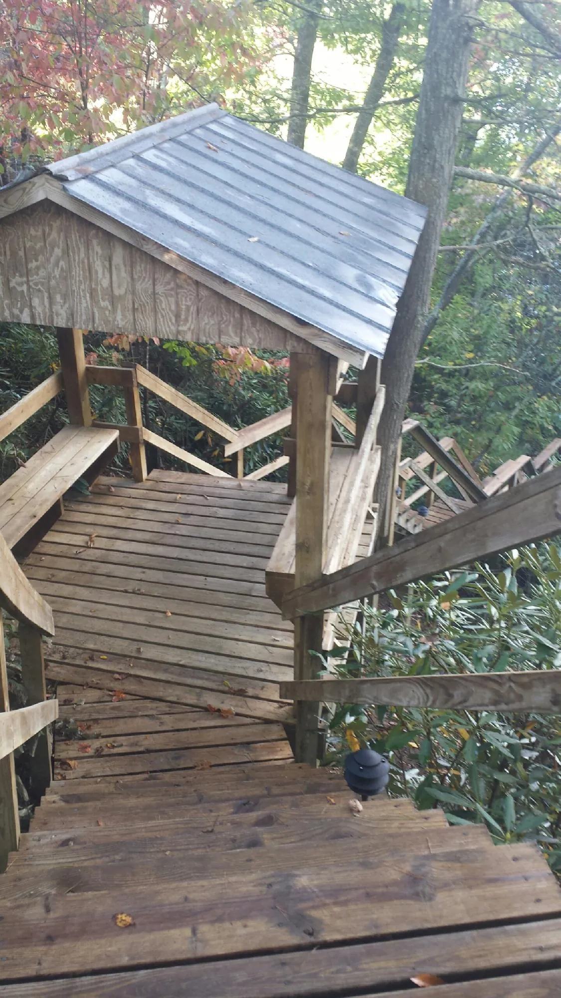 Metal roofed shelter over wooden steps on a wooded walkway — Skylight Repair & Installation work by our crew in Cedarburg